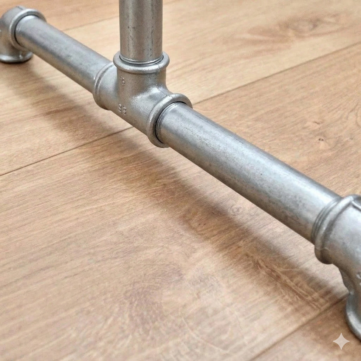 Detalhe do pé do suporte para cabides galvanizado com conexões em ferro fundido e tubos roscados