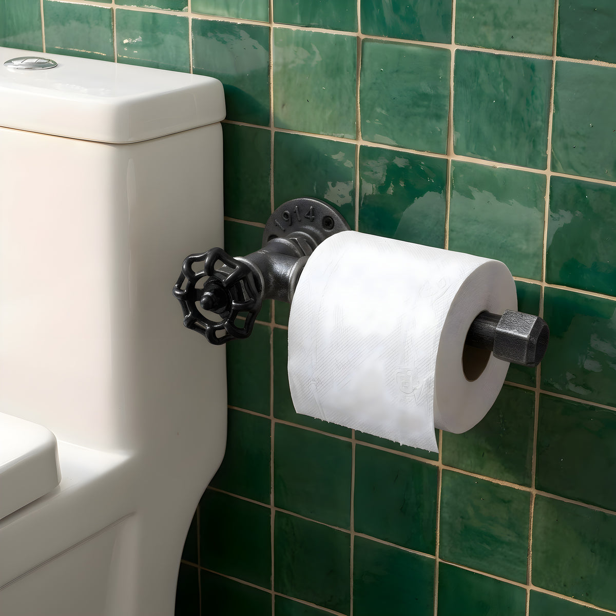 Suporte de rolo em ferro fundido preto com volante, fixado numa parede de azulejos zellige verdes ao lado da sanita