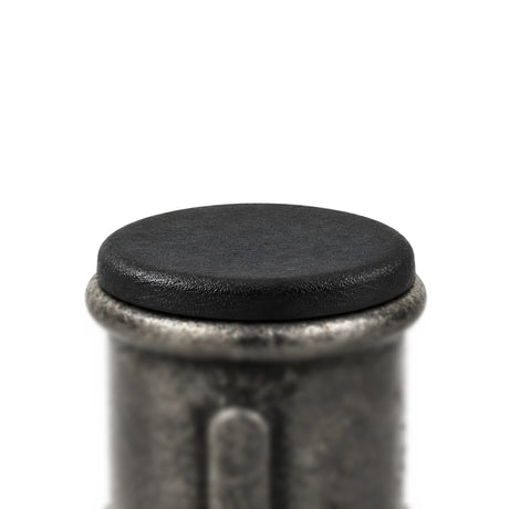 Tampão de plástico preto colocado numa luva em ferro fundido preto Premium, cabeça plana apoiada na borda