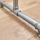 Detalhe do pé do suporte para cabides galvanizado com conexões em ferro fundido e tubos roscados